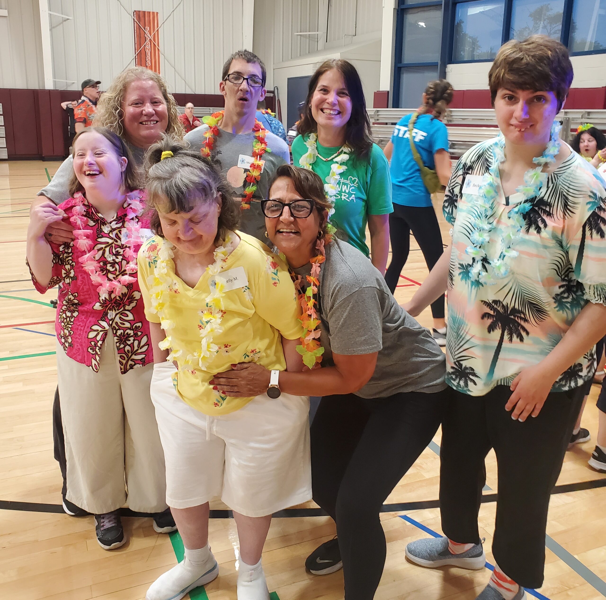 7 adult participants with leis at Luau Dance in gym
