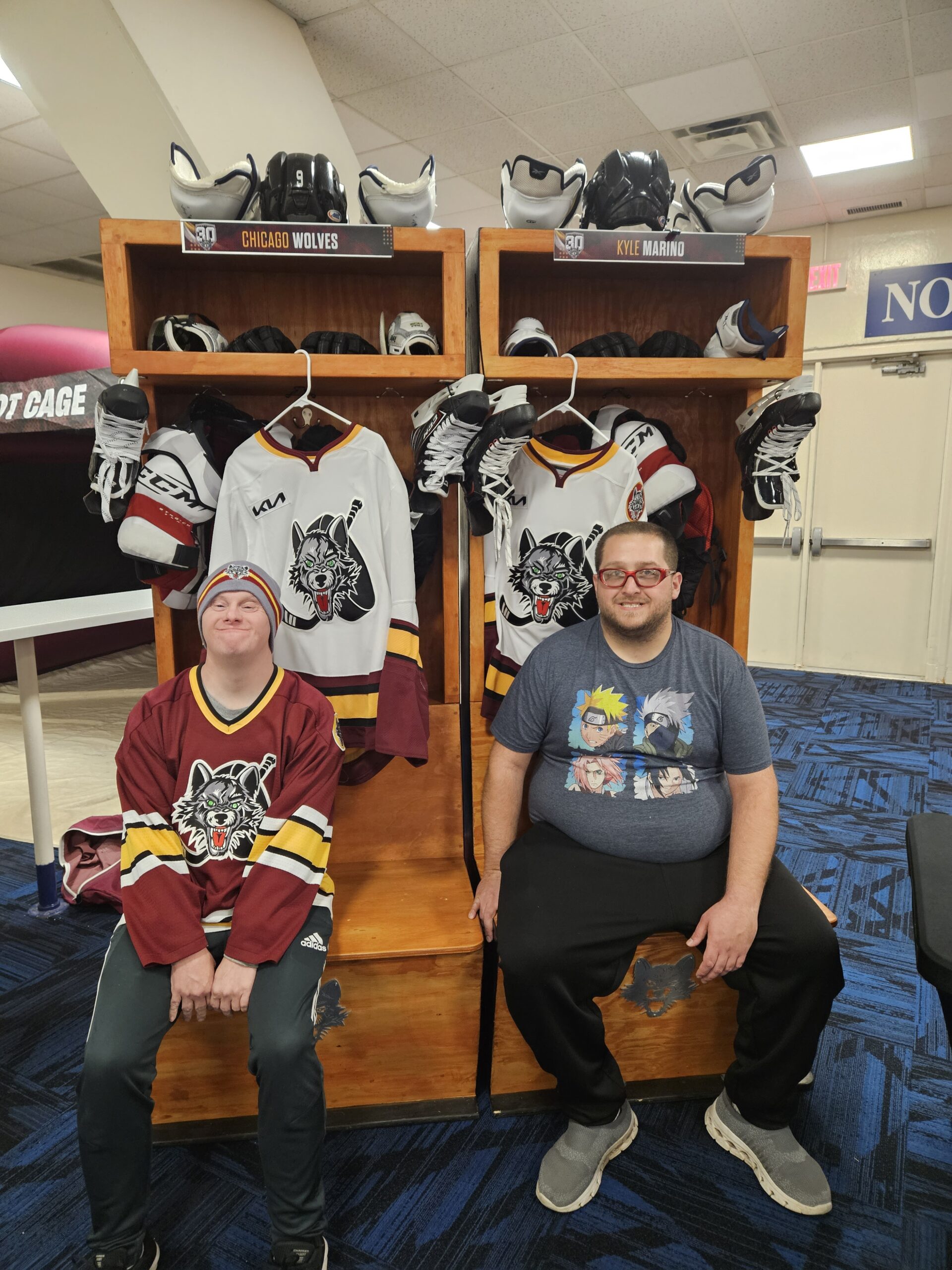 Two male participants in Wolves locker room with gear and helmuts