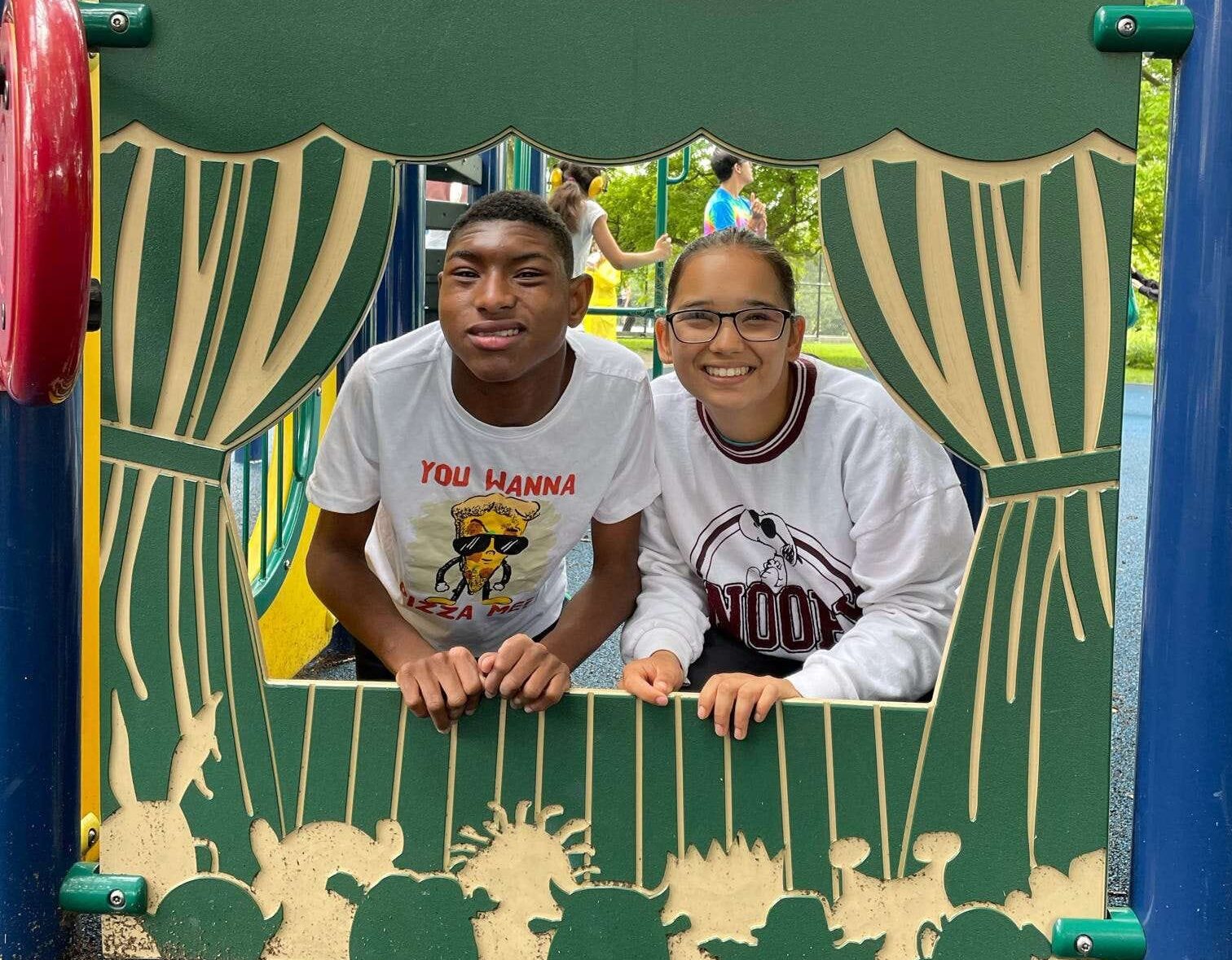 Young boy with staff in puppet show cutout at outdoor park